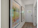 Inviting entryway featuring beautiful art, luxury vinyl plank flooring and natural light from the front door at 25 Granite Falls Way, Youngsville, NC 27596