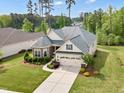 An eye-level view of a lovely home boasts professional landscaping, lush greenery, and a driveway at 2613 Beckwith Rd, Apex, NC 27523
