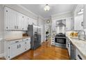Bright kitchen with white cabinets, stainless steel appliances, and granite countertops at 2613 Hiking Trl, Raleigh, NC 27615