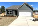 Picture of a new home featuring an attached two-car garage, gray siding, a gray roof, and a well-lit driveway at 288 Olivia Crossing Ct # 10, Four Oaks, NC 27524