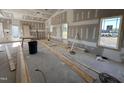 Spacious living room displaying natural light from the windows and featuring unfinished drywall at 2895 Bakers Chapel Rd, Smithfield, NC 27577