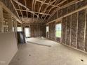 Spacious living room under construction, featuring new insulation, open framing, and ample natural light from multiple windows at 2895 Bakers Chapel Rd, Smithfield, NC 27577