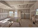 Bright living room features drywall and natural light from the windows overlooking the neighborhood at 2895 Bakers Chapel Rd, Smithfield, NC 27577