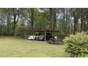 View of a backyard carport featuring two vehicles and a picnic table at 300 E Vance St, Zebulon, NC 27597