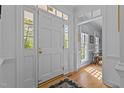 Bright foyer featuring hardwood floors, a front door with sidelights, and an open view to another room at 3308 Churchill Rd, Raleigh, NC 27607