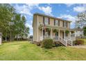 Well-manicured lawn, a front porch, and a flag accent this charming home's inviting exterior at 34 Stuart Dr, Benson, NC 27504