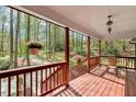 Inviting porch with wood floors, rustic railings, and a peaceful view of the wooded landscape at 3508 Cole Mill Rd, Durham, NC 27712