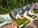 Aerial view of a modern home with manicured lawn and landscaping, surrounded by lush greenery at 3832 Noremac Dr, Raleigh, NC 27612