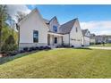 Stunning modern farmhouse with white siding, stone accents, and a well-manicured lawn at 3832 Noremac Dr, Raleigh, NC 27612