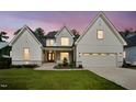 Inviting two-story home with a white exterior, stone details, and a professionally landscaped front yard at 3832 Noremac Dr, Raleigh, NC 27612