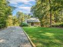 Quaint home nestled amongst mature trees with a manicured lawn at 3900 Maplefield Dr, Raleigh, NC 27613