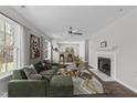 Bright living room featuring a cozy fireplace, ceiling fan, and view to adjacent dining area at 420 Feldspar Way, Durham, NC 27703
