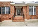 Close-up view of a classic brick home's front entrance, showcasing a detailed glass door and brick steps at 48 Arabella Ln, Clayton, NC 27520