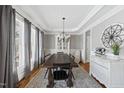 Elegant dining room with hardwood floors, large windows, and stylish chandelier at 504 Skygrove Dr, Holly Springs, NC 27540