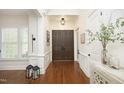 Elegant foyer featuring dark wood floors, white trim, plantation shutters and stylish decor with double front doors at 515 Bexley Bluff Ln, Cary, NC 27513