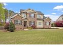 Charming two-story house features a lush green lawn, brick accents, and a welcoming front entrance at 603 Goal Kick Dr, Fuquay Varina, NC 27526