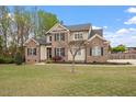 Inviting two-story home showcasing a green lawn, brick detailing, and a well-landscaped yard at 603 Goal Kick Dr, Fuquay Varina, NC 27526