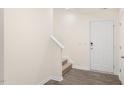 Bright entryway featuring hard surface floors, staircase, coat closet, and a white entry door at 6049 Sodium St, Raleigh, NC 27610