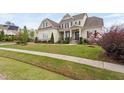 Beautifully landscaped two-story home featuring a stone facade, covered porch, and well-maintained lawn at 7825 Green Hope School Rd, Cary, NC 27519