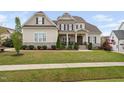 Charming two-story home featuring stone accents, a covered porch, and beautifully landscaped front yard at 7825 Green Hope School Rd, Cary, NC 27519