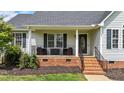Inviting front porch with seating, a decorative door, and manicured landscaping at 82 Sommerset Dr, Clayton, NC 27520