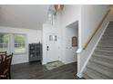 Bright entryway with high ceilings, modern light fixture, a gray cabinet, and staircase leading to the upper level at 105 Guldahl Ct, Morrisville, NC 27560