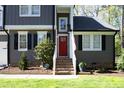 A close-up of the front door with a small garden, stairs, and an American flag, offering a warm welcome at 105 Guldahl Ct, Morrisville, NC 27560