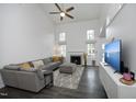 Spacious living room featuring high ceilings, a fireplace, a sectional sofa, and natural light from ample windows at 105 Guldahl Ct, Morrisville, NC 27560