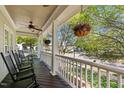 Relaxing front porch featuring rocking chairs, hanging flower baskets, and a ceiling fan at 119 Weaver Mine Trl, Chapel Hill, NC 27517