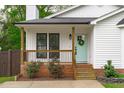 Close up of the front porch with black railings, light green front door, and front lawn at 120 Cabrita Ct, Holly Springs, NC 27540