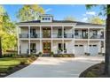 Charming two-story home boasts a double-decker porch and well-manicured lawn on a sunny day at 1213 Rocky Point Ln, Durham, NC 27712
