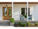 Inviting front porch with stone steps, rocking chairs and a beautiful wood door at 1213 Rocky Point Ln, Durham, NC 27712