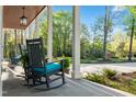 Comfortable seating on the covered front porch with a scenic view of the landscaped yard at 1213 Rocky Point Ln, Durham, NC 27712