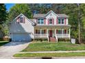Charming two-story home with a manicured lawn, attached garage, and inviting front porch at 1310 Country Club Dr, Durham, NC 27712
