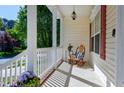 Inviting front porch featuring a rocking chair, side table, and decorative potted plants at 1310 Country Club Dr, Durham, NC 27712