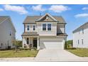 Charming two-story home featuring attached garage, inviting front porch, and manicured lawn at 135 Carlton Ln, Franklinton, NC 27525