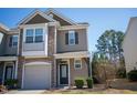 Exterior angle of a neutral two-story home featuring a stone facade, balcony, and garage at 157 Durants Neck Ln, Morrisville, NC 27560