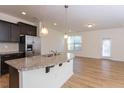 Open kitchen featuring an island, granite counters, stainless steel appliances, and a dining area at 157 Durants Neck Ln, Morrisville, NC 27560