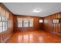 Spacious living room showcases wood paneling, ample natural light, and hardwood floors, exuding warmth and character at 1631 Sunset Ave, Henderson, NC 27536