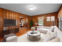 Cozy living room featuring wood paneling, a neutral sofa, and an open layout, perfect for relaxation at 1631 Sunset Ave, Henderson, NC 27536