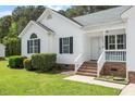 Inviting front porch and manicured lawn enhance this single-story home's curb appeal at 1752 Cobblestone Dr, Creedmoor, NC 27522