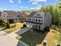 Beautiful aerial view of a gray two-story home with a manicured lawn in a residential neighborhood at 1840 Flint Valley Ln, Apex, NC 27502