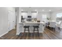 Stylish kitchen featuring white cabinets, stainless steel appliances, an island with stool seating, and adjacent dining area at 20 Carolina Maple Dr, Franklinton, NC 27525