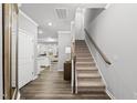 Bright foyer featuring hardwood floors, staircase, and views into the kitchen and living areas at 205 Fig Tree Bnd, Zebulon, NC 27597