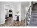 Inviting hallway showcasing hardwood floors, stairs, and an arched doorway leading to the living room at 2113 Conroy Way, Willow Springs, NC 27592