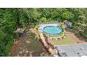 Aerial view of backyard, featuring a charming above-ground pool with a deck, surrounding by beautiful greenery at 2120 Hillock Dr, Raleigh, NC 27612