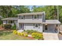 Charming home features a gray exterior, manicured lawn, lush landscaping, and eye-catching purple door at 2120 Hillock Dr, Raleigh, NC 27612