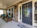 Cozy front porch featuring stone accents, wicker furniture, and ceiling fan perfect for outdoor relaxation at 2125 Toad Hollow Trl, Apex, NC 27502
