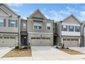 Inviting townhome exterior featuring a two-car garage, tidy landscaping, and appealing architectural details under a sunny sky at 2129 Mars Hill Ln, Apex, NC 27502