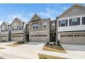Attractive townhome showcasing a well-kept lawn, two-car garage, and modern design elements on a bright, clear day at 2129 Mars Hill Ln, Apex, NC 27502